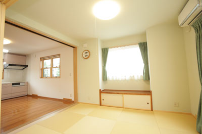 ダイニングから畳のリビングへの間仕切りは天井まで伸びた明るい3枚引き戸で、オープンな空間で。